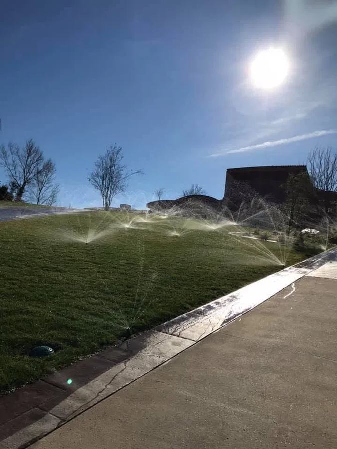 Sprinkler irrigation system running on a sloped front lawn